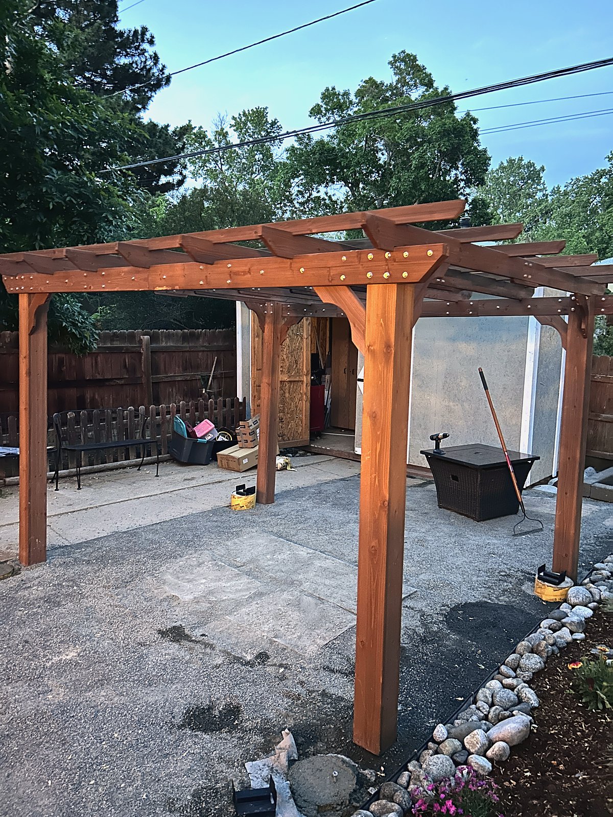 Cedar pergola standing over a flagstone patio at dusk