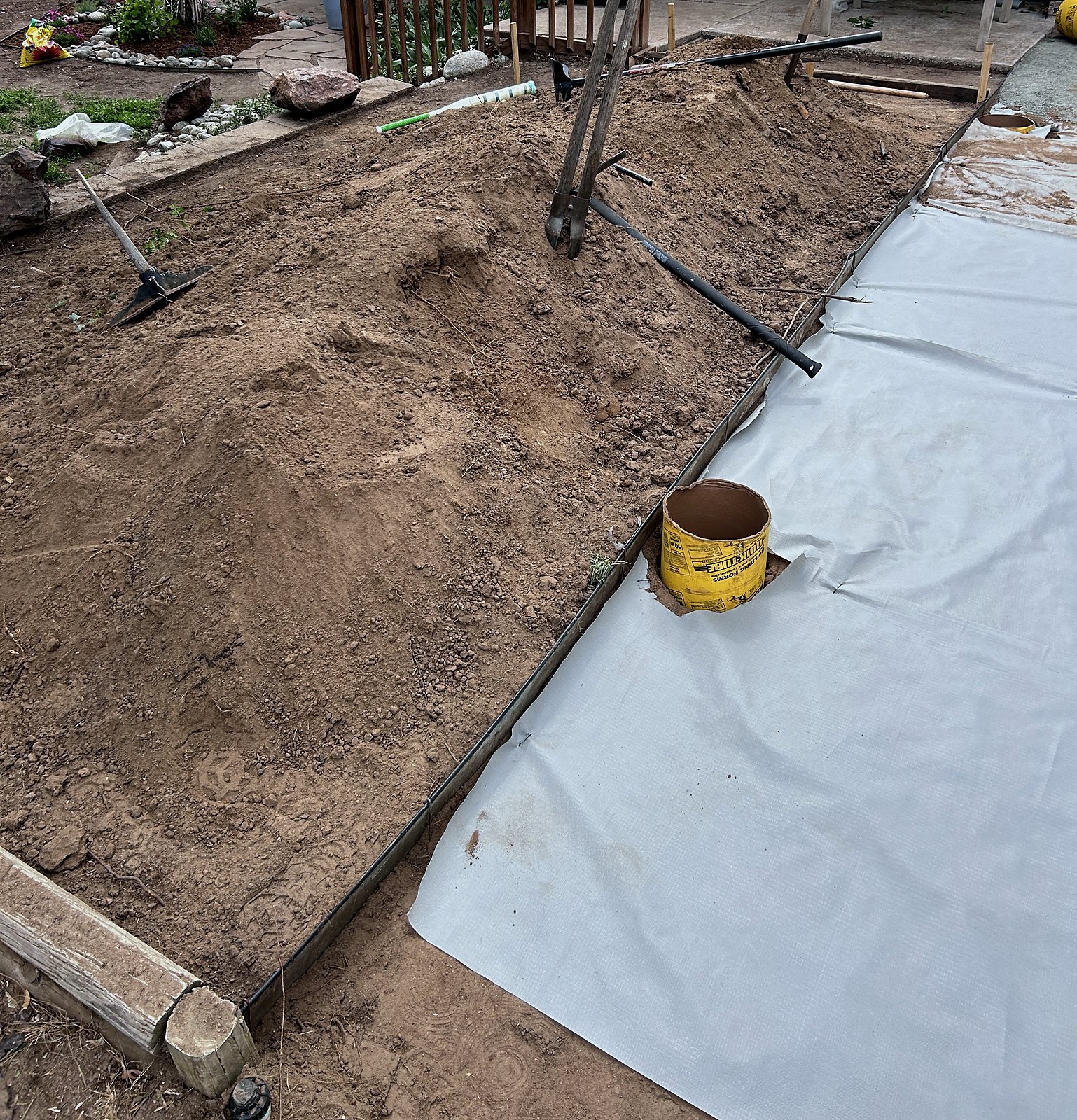 Edging set and weed barrier laid along the patio line